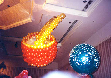 This five foot balloon toy drum is suspended from the ceiling of a Fairmont Hotel ball room for a toyland theme holiday party where guests were surrounded by toys as big as themselves