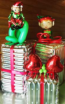 A pair of four-foot tall balloon sculpture elves playing in the gift packages awaiting delivery