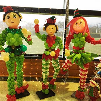 A trio of three five-foot tall balloon sculpture elves for a Santa's workshop venue