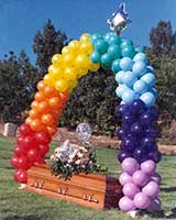 This packed style balloon arch in the colors of the rainbow was part of a grave side memorial service