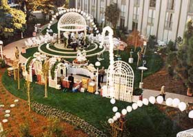 This glistening white bouncing string-of-pearls style balloon arch frames the entire area for an outdoor wedding reception at a bay area hotel.