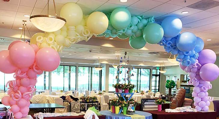 A 20 foot long pastel colored organic style balloon arch as a buffet table focal decoration