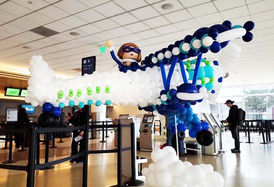 A 10' long blue and white balloon sculpture of a biplane fly-by at San Jose Internaational Airport for a promotion by Alaska Airlines
