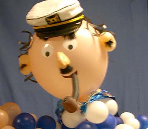 A six foot tall caricature-style balloon sculpture of a crusty old seaman in seaman's hat enjoying his balloon pipe for a sea theme party