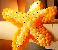 Giant yellow and white balloon sculpture of a starfish