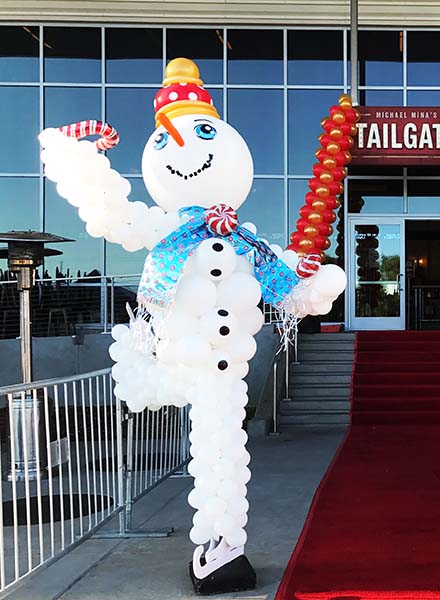 A six foot tall balloon sculpture of a giant snowman on figure skates