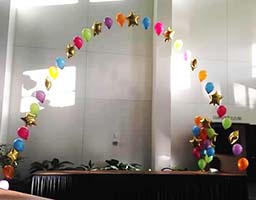 String-of-Pearls style balloon arch interspersed with mylar star balloons for a celebration event