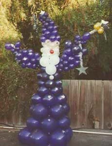 A seven foot tall bearded balloon sculpture wizzard in a quartz balloon robe