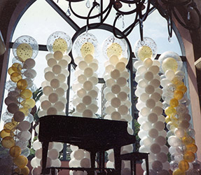 These ten foot tall swirled columns of white, clear, and gold provide an elegant background decoration for this grand piano