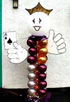 A 7 foot tall balloon column greeter figure of gold and magenta balloons topped by a white 