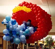 A giant red balloon bucket sculpture suspended from the ceiling gives the feeling of playing on the seashore