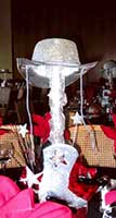 A silver colored cowboy boot topped by a cowboy hat serves a centerpiece for a western theme event