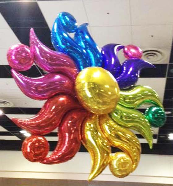 A five foot diameter mylar sun balloon decoration suspended from a venue ceiling