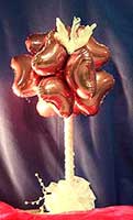 A wedding theme centerpiece with a cluster of mini balloon hearts and a dove