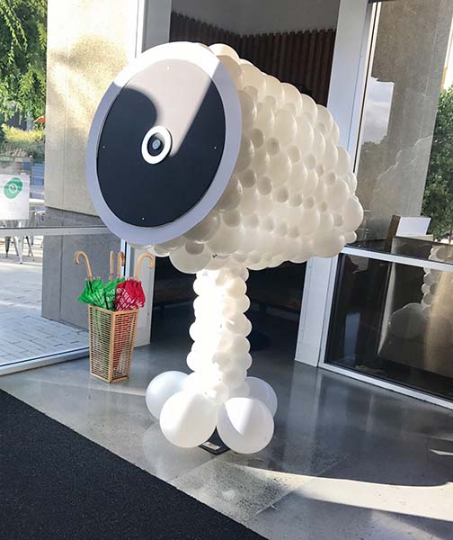 A seven foot tall balloon sculpture of a Nest Cam Camera serving as a lobby decor piece