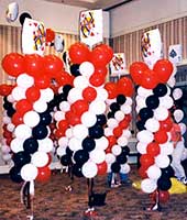Seven-foot tall columns of swirled red, white and black latex balloons topped by playing card mylar balloons for a casino theme event