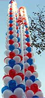 Fifty foot tall columns of swirled red, white and blue columns flank a flagpole for a July 4th event