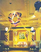 This 5 foot tall balloon heart sculpture is suspended from the ceiling as a focal decoration at a wedding reception