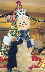 This eight foot tall snowman sculpture has personality and style with foamcor hat and mittens, and serves as a major focal decor piece for a holiday party.