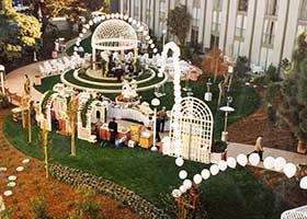 This glistening white bouncing string-of-pearls style balloon arch frames the entire area for an outdoor wedding reception at a bay area hotel.
