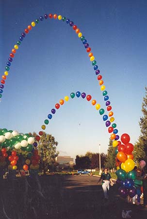 This 40 foot tall string-of-pearls style balloon arch is constructed in rainbow colors from equally spaced single balloons to visually carry the eye skyward.