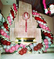 Garlands of silver, pink and burgundy balloons flank the fireplace in a private residence.