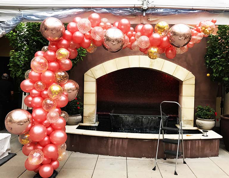 An 10 foot organic style vine of copper and gold colored chrome balloons for an interior decor piece.