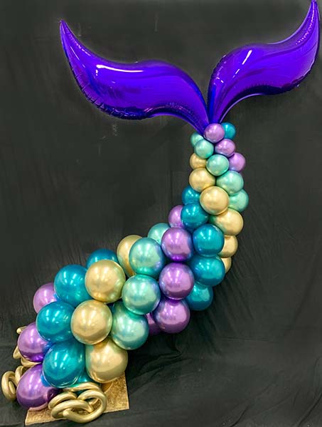 An 8 foot chrome balloon column sculpted as a whale's tail.